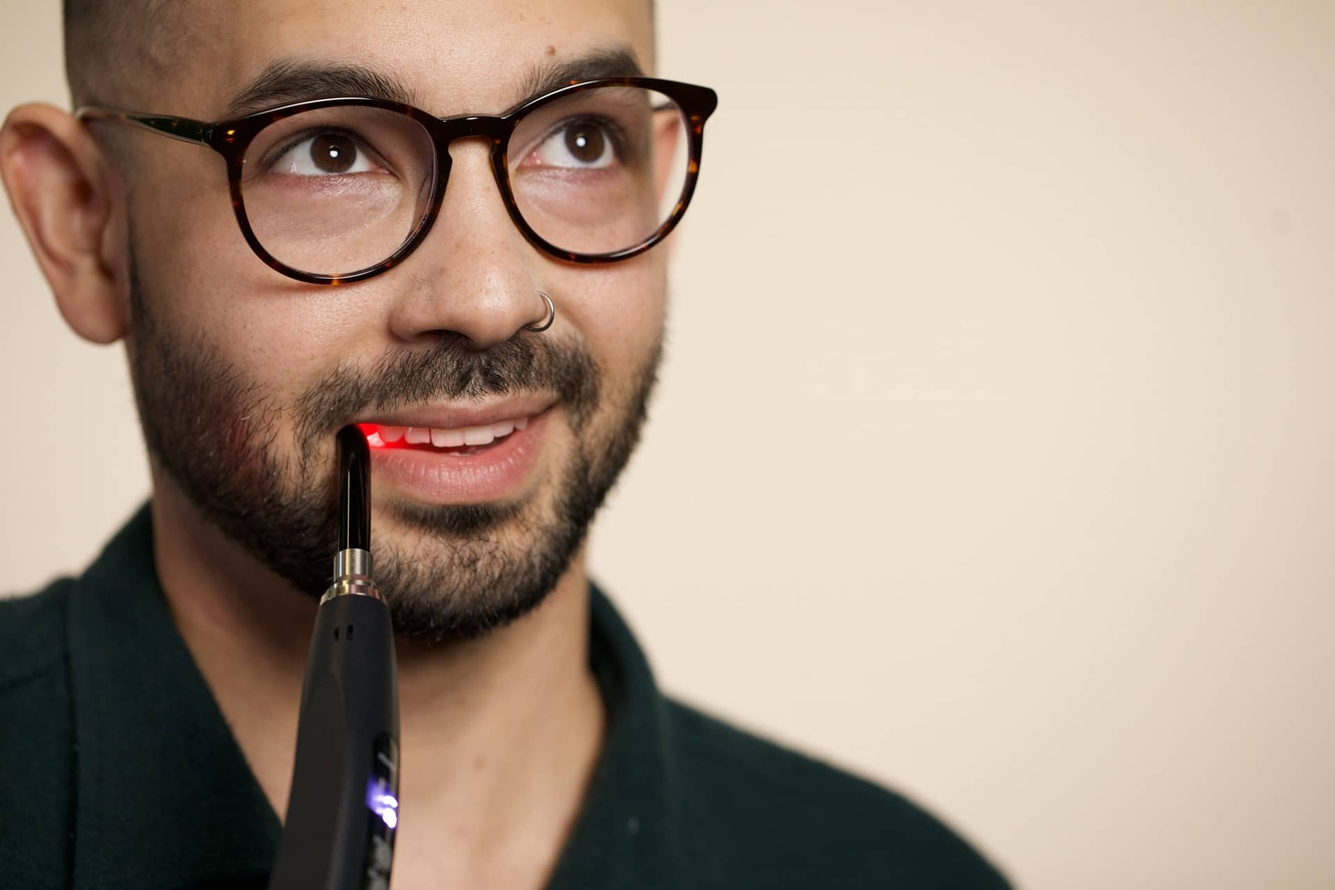 A man in glasses finally uses the Luminance RED handheld device because he keeps getting canker sores.