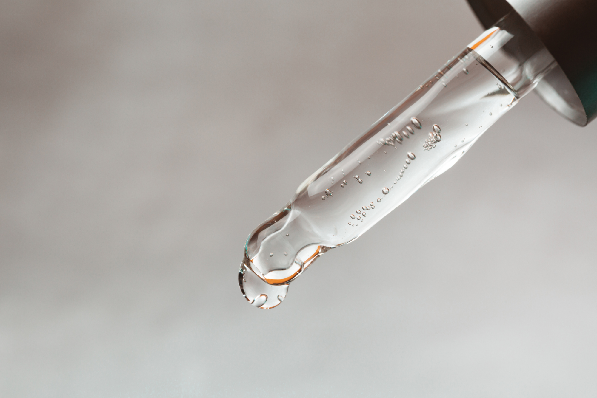 A dropper full of glycolic acid represents the connection between glycolic acid and LED light therapy.